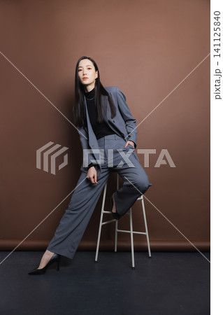 椅子に座るスーツの女性 椅子に座るスーツの女性 141125840