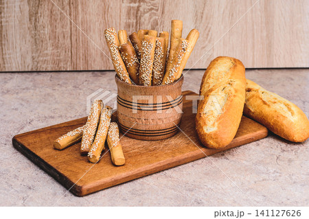 French baguettes. Fresh crispbread. Bread background. Different breed on wooden background. French baguettes. Fresh crispbread. Bread background. Different breed on wooden background. 141127626