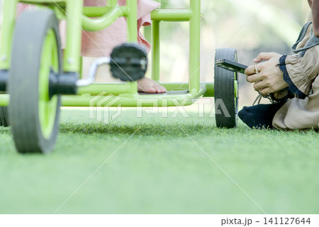 Detail of Child's Legs on Green Ride-On Toy Detail of Child's Legs on Green Ride-On Toy 141127644