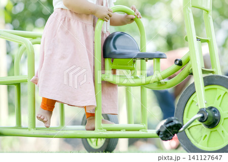 Detail of Child's Legs on Green Ride-On Toy Detail of Child's Legs on Green Ride-On Toy 141127647