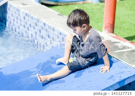 Child Relaxing on Green Grass Outdoors Child Relaxing on Green Grass Outdoors 141127713