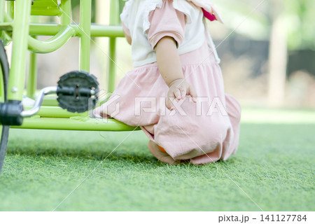 happy little girl riding bicycle in the park happy little girl riding bicycle in the park 141127784