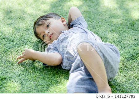 asian boy lying on grass asian boy lying on grass 141127792