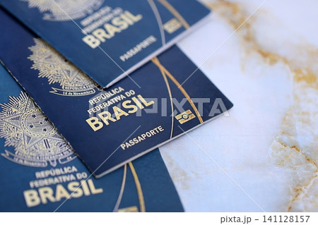 Three brazilian passports on table close up. Official identification document books for citizens of Brazil. Concept of travel and tourism Three brazilian passports on table close up. Official identification document books for citizens of Brazil. Concept of travel and tourism 141128157