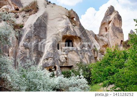 Rock formations in Cappadocia show ancient dwellings under a blue sky with white clouds Rock formations in Cappadocia show ancient dwellings under a blue sky with white clouds 141128252