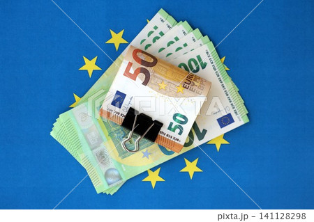 European euro currency money notes bunch on Europe union blue flag close up European euro currency money notes bunch on Europe union blue flag close up 141128298