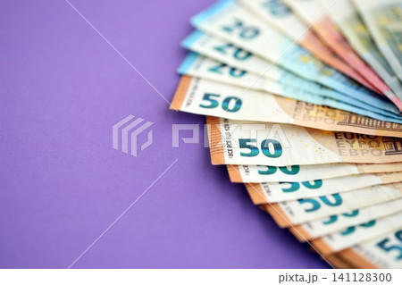 Big amount of european euro currency money notes on purple color table close up Big amount of european euro currency money notes on purple color table close up 141128300
