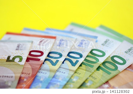 Big amount of european euro currency money notes on yellow color table close up Big amount of european euro currency money notes on yellow color table close up 141128302