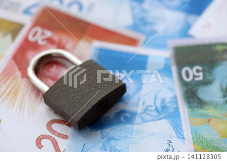 Israel New Shekels banknotes and padlock. The current Israel money bills and lock lies on table Israel New Shekels banknotes and padlock. The current Israel money bills and lock lies on table 141128305