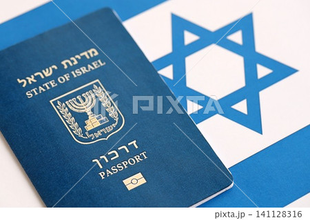 Israel passport on flag. The current Israel biometrical pass lies on flag close up Israel passport on flag. The current Israel biometrical pass lies on flag close up 141128316