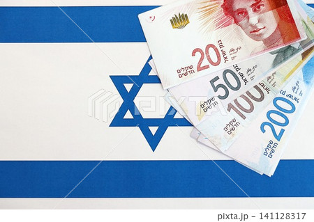 Israel New Shekels banknotes on national flag. The current Israel money bills lies on flag Israel New Shekels banknotes on national flag. The current Israel money bills lies on flag 141128317