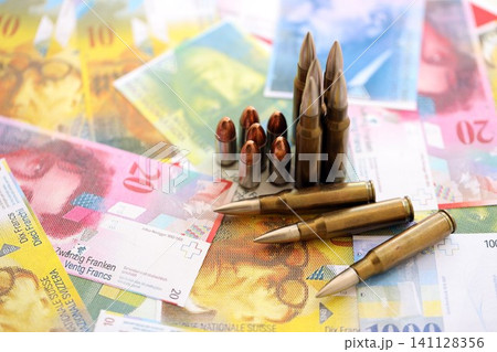 Swiss franc banknotes and bullets. The current francs money bills and ammo lies on table 141128356