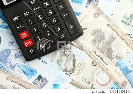 United Arab Emirates dirham currency money bills and calculator. The concept of taxation and money count United Arab Emirates dirham currency money bills and calculator. The concept of taxation and money count 141128416