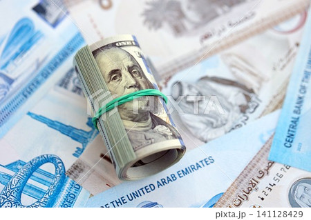 United Arab Emirates dirham currency money bills and bunch of us dollar banknotes. The concept of economics and currency exchange United Arab Emirates dirham currency money bills and bunch of us dollar banknotes. The concept of economics and currency exchange 141128429