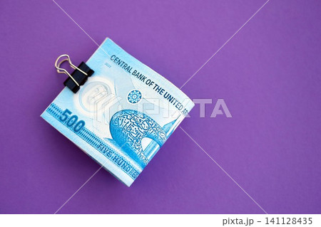 United Arab Emirates dirham money bills in big amount on purple. Finance and banking concept United Arab Emirates dirham money bills in big amount on purple. Finance and banking concept 141128435