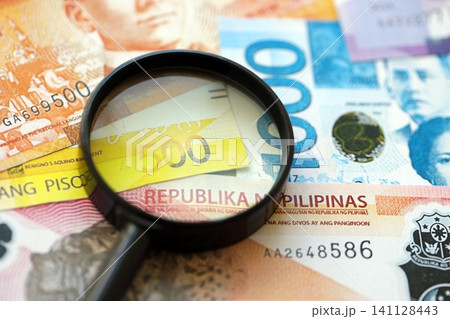 Philippines peso currency money bills and magnifying glass. The concept of financial monitoring and taxation 141128443