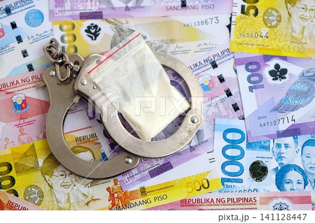 Philippines peso currency money bills and cocaine pack with handcuffs. The concept of drug crimes 141128447