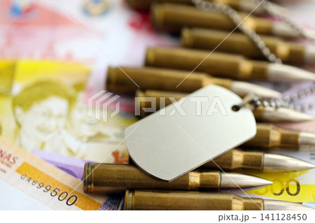 Philippines peso currency money bills and rifle bullets with dogtag. The concept of warfare and army service 141128450