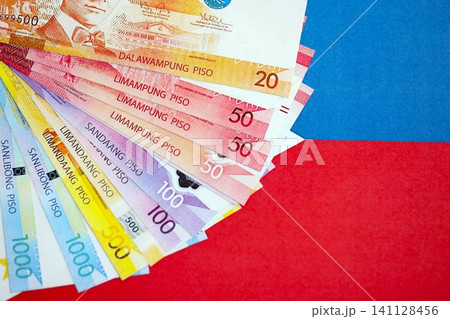Philippines peso currency money bills lies on flag. The concept of business and investment Philippines peso currency money bills lies on flag. The concept of business and investment 141128456