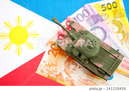 Philippines peso currency money bills and toy tank on flag. The concept of army funds and weapons sales 141128458