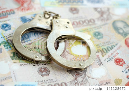 Vietnamese dong currency money bills and handcuffs. The concept of criminal Vietnamese dong currency money bills and handcuffs. The concept of criminal 141128472