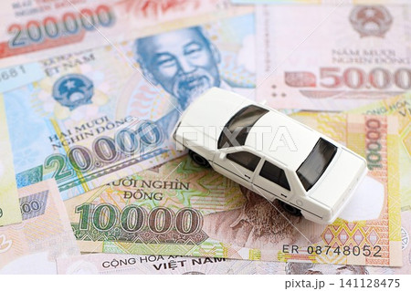 Vietnamese dong currency money bills and toy car. The concept of car ownership Vietnamese dong currency money bills and toy car. The concept of car ownership 141128475