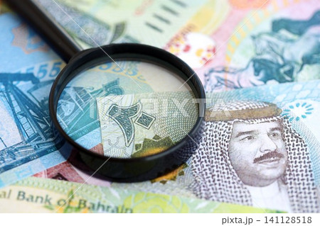 Bahraini dinar currency money bills and magnifying glass. The concept of financial monitoring 141128518