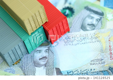 Bahraini dinar currency money bills and toy cargo containers. The concept of shipping and logistics Bahraini dinar currency money bills and toy cargo containers. The concept of shipping and logistics 141128525