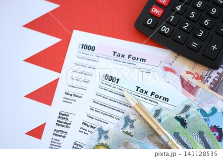 Bahraini dinar money bills and calculator with tax form on flag. Taxation and accounting concept Bahraini dinar money bills and calculator with tax form on flag. Taxation and accounting concept 141128535