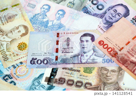 Thai baht currency money. The current banknotes lies on table in big amount Thai baht currency money. The current banknotes lies on table in big amount 141128541