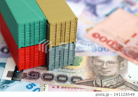 Thai baht currency money bills and toy cargo containers. The concept of shipping and logistics Thai baht currency money bills and toy cargo containers. The concept of shipping and logistics 141128549
