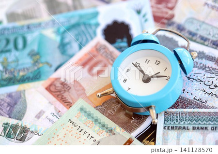 Egyptian pound currency money bills and alarm clock. The concept of time management and income 141128570