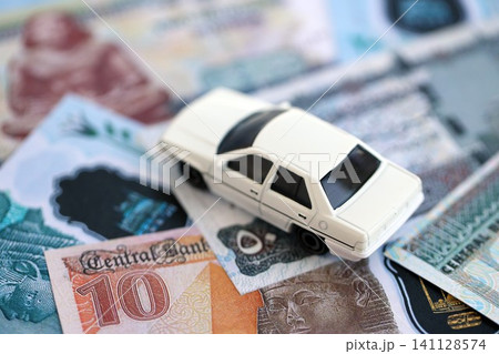 Egyptian pound currency money bills and toy car. The concept of car ownership Egyptian pound currency money bills and toy car. The concept of car ownership 141128574