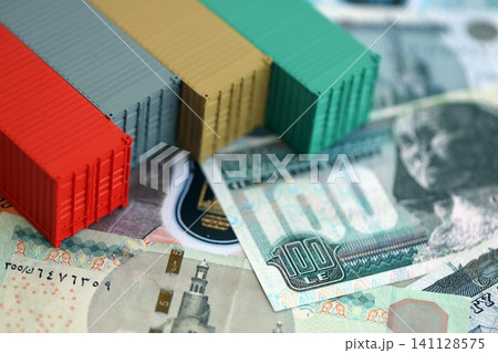 Egyptian pound currency money bills and toy cargo containers. The concept of shipping and logistics Egyptian pound currency money bills and toy cargo containers. The concept of shipping and logistics 141128575