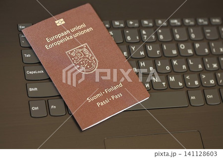 Finland passport lies on black laptop keyboard buttons background . Technologies in Europe 141128603