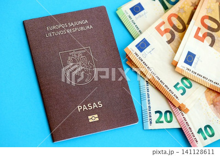 Lithuania passport lies with euro money banknotes on blue background. Salary and pension in Europe 141128611