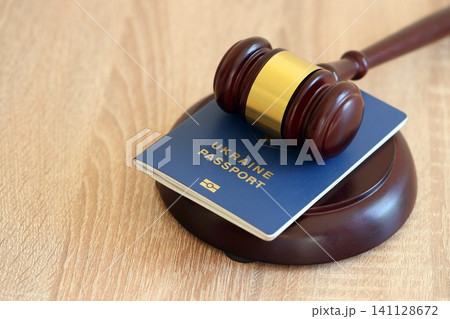 Judge hammer and ukrainian passport on brown background. Passport Of Ukraine Judge hammer and ukrainian passport on brown background. Passport Of Ukraine 141128672