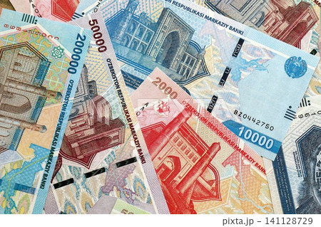 Uzbek som money bills pile on table. Uzbekistan banknotes of UZN currency close up Uzbek som money bills pile on table. Uzbekistan banknotes of UZN currency close up 141128729