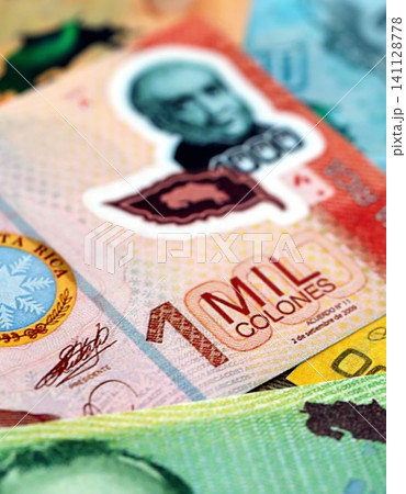 Costa Rican colon money bills pile on table. Costa Rica banknotes of CRC currency close up Costa Rican colon money bills pile on table. Costa Rica banknotes of CRC currency close up 141128778