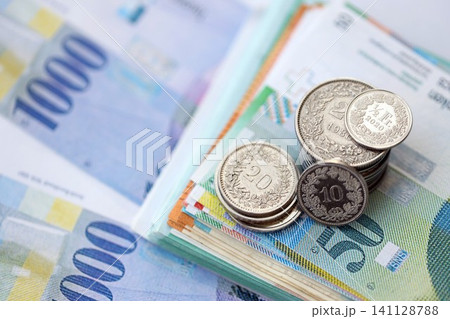 Swiss franc money bills and cent coins pile on table. Switzerland coins on banknotes of CHF currency 141128788