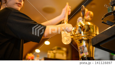 ビールサーバーからビールを注ぐ女性の手 141128897