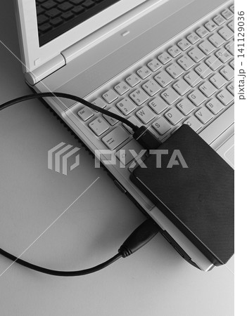 External Hard Drive Connected To White Laptop On Clean White Table External Hard Drive Connected To White Laptop On Clean White Table 141129036