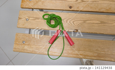 Skipping rope. Fitness, Dieting, healthy lifestyle Concept, Sport Item exercise accessories, running shoes, Lockers in gym locker room background. Copy space. Indoor workout. Wellness exercise. Skipping rope. Fitness, Dieting, healthy lifestyle Concept, Sport Item exercise accessories, running shoes, Lockers in gym locker room background. Copy space. Indoor workout. Wellness exercise. 141129438