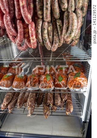 Naples, italy. December 27, 2024. Butcher shop displaying fresh and cured italian sausages, salami, and prepared meats, showcasing traditional neapolitan deli products Naples, italy. December 27, 2024. Butcher shop displaying fresh and cured italian sausages, salami, and prepared meats, showcasing traditional neapolitan deli products 141129572
