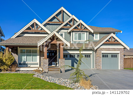 Contemporary Suburban Family Home with Stone Facade and Blue Sky Background Contemporary Suburban Family Home with Stone Facade and Blue Sky Background 141129702