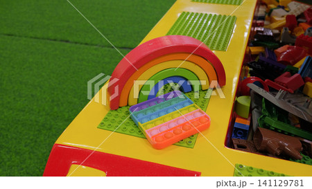 Comfortable vivid multicolored kids playroom or kindergarten nursery interior design with kid toys, play space. Bright and spacious colorful game room for children with plastic educational blocks toys Comfortable vivid multicolored kids playroom or kindergarten nursery interior design with kid toys, play space. Bright and spacious colorful game room for children with plastic educational blocks toys 141129781
