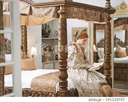 Woman, queen and book with reading for renaissance, royalty aesthetic and confidence on palace bed. Monarch, wealthy person and elegant dress for cosplay, regal and medieval knowledge in the castle Woman, queen and book with reading for renaissance, royalty aesthetic and confidence on palace bed. Monarch, wealthy person and elegant dress for cosplay, regal and medieval knowledge in the castle 141129787