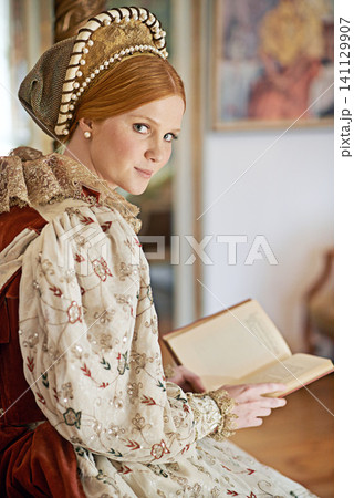 Woman, queen and book with portrait for renaissance, royalty aesthetic and reading in palace bedroom. Monarch, wealthy person and elegant dress for cosplay, regal and medieval knowledge in the castle Woman, queen and book with portrait for renaissance, royalty aesthetic and reading in palace bedroom. Monarch, wealthy person and elegant dress for cosplay, regal and medieval knowledge in the castle 141129907