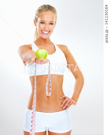 Smile, measuring tape and portrait of woman with apple for vitamin c, healthy diet or weight loss progress. Studio, happy and person with fruit for nutrition, detox and wellness on white background Smile, measuring tape and portrait of woman with apple for vitamin c, healthy diet or weight loss progress. Studio, happy and person with fruit for nutrition, detox and wellness on white background 141130164