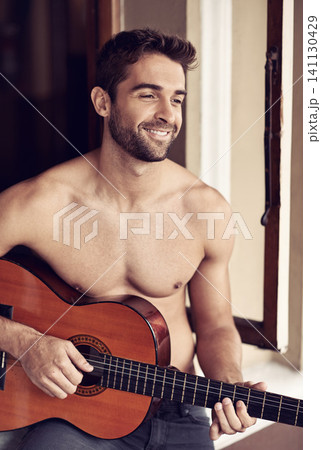 Man, guitar or home to relax as inspiration, thinking or idea of future, or vision on break with smile. Memory, shirtless or happy artist playing with musical instrument to remember, chill or rest Man, guitar or home to relax as inspiration, thinking or idea of future, or vision on break with smile. Memory, shirtless or happy artist playing with musical instrument to remember, chill or rest 141130429